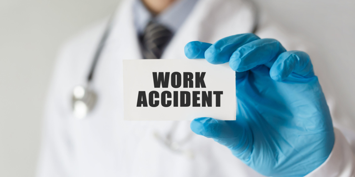 Doctor holding a card with text Work Accident, medical concept