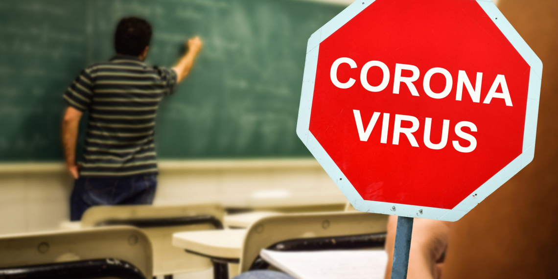 Red sign warning of coronavirus in school or university classroom. Concept for closing schools or universities for quarantine because of covid pandemic