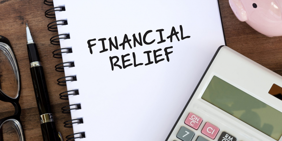 Financial Relief text on note pad with calculator and piggy bank